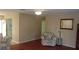 Living room with hardwood floors, floral armchair, and view into kitchen at 10470 Sw 99Th Ave, Ocala, FL 34481