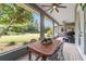 Screened porch with outdoor dining set and lush yard views at 1105 Se 48Th Ave, Ocala, FL 34471