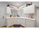 White kitchen with corner sink and ample storage at 13309 Se 92Nd Court Rd, Summerfield, FL 34491