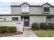 Two-story townhome with gray siding, a blue door, and well-manicured landscaping at 1903 Se 37Th Court Cir, Ocala, FL 34471