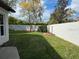 Green grassy backyard with a white wall and small garden at 2011 Se Twin Bridge Cir, Ocala, FL 34471