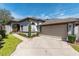 One story home with attached garage and manicured lawn at 2011 Se Twin Bridge Cir, Ocala, FL 34471