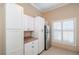 White kitchen cabinets and stainless steel refrigerator at 2011 Se Twin Bridge Cir, Ocala, FL 34471