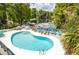 Community pool with lounge chairs and waterfront views at 20820 River Dr # B17, Dunnellon, FL 34431