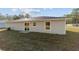 House exterior showcasing gray siding, sliding glass door, and a small patio at 2295 Sw 142Nd Court Rd, Ocala, FL 34481