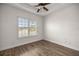 Well-lit bedroom with wood-look flooring and plantation shutters at 5015 Belted Kingfisher Dr, Oxford, FL 34484