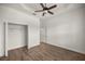 Bedroom with wood-look floors, ceiling fan, and a spacious closet at 5015 Belted Kingfisher Dr, Oxford, FL 34484