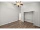 Bedroom with wood-look floors, ceiling fan, and a large closet at 5015 Belted Kingfisher Dr, Oxford, FL 34484