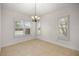 Bright dining room with chandelier, large windows, and tile flooring at 5015 Belted Kingfisher Dr, Oxford, FL 34484