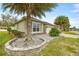 Landscaped curb appeal with palm trees and stone accents at 5015 Belted Kingfisher Dr, Oxford, FL 34484