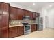 Kitchen with dark wood cabinets and stainless steel appliances at 5015 Belted Kingfisher Dr, Oxford, FL 34484