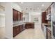 Spacious kitchen featuring dark wood cabinets, granite countertops, and stainless steel appliances at 5015 Belted Kingfisher Dr, Oxford, FL 34484