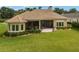 House back elevation with covered patio and lush lawn at 7549 Nw 33Rd Pl, Ocala, FL 34482