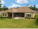 House back elevation with covered patio and lush lawn at 7549 Nw 33Rd Pl, Ocala, FL 34482