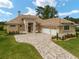 Tan house with tile roof, three-car garage, and landscaped yard at 7549 Nw 33Rd Pl, Ocala, FL 34482