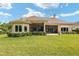 Tan house with covered patio and manicured lawn at 7549 Nw 33Rd Pl, Ocala, FL 34482