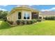 Side view of tan house with well-manicured landscaping at 7549 Nw 33Rd Pl, Ocala, FL 34482