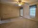 Spacious bedroom with carpet, ceiling fan, and window coverings at 8009 County Road 109D, Lady Lake, FL 32159