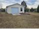 Single car detached garage with a window and concrete driveway at 8009 County Road 109D, Lady Lake, FL 32159