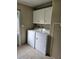 Laundry room with washer, dryer, and overhead cabinets at 8009 County Road 109D, Lady Lake, FL 32159