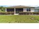 Rear view of house with screened porch and neatly landscaped yard at 8230 Sw 78Th Cir, Ocala, FL 34476