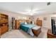 Comfortable bedroom featuring a ceiling fan, dresser, and a view into the bathroom at 8961 Sw 94Th Ln # C, Ocala, FL 34481