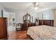 Bedroom with hardwood floors, dresser and four-poster bed at 9203 Se 179Th Lunsford Ln, The Villages, FL 32162