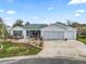 House exterior showcasing a two-car garage and well-maintained landscaping at 9203 Se 179Th Lunsford Ln, The Villages, FL 32162