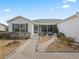 Landscaped front yard with a walkway leading to a screened porch at 9203 Se 179Th Lunsford Ln, The Villages, FL 32162