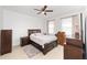 Well-lit bedroom with dark wood furniture, a comfortable bed, and tile flooring, ready for relaxation at 10871 Sw 62Nd Avenue Rd, Ocala, FL 34476