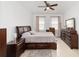 Cozy bedroom with dark wood furniture, a ceiling fan, and neutral decor, providing a tranquil retreat at 10871 Sw 62Nd Avenue Rd, Ocala, FL 34476