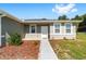 Close-up of a home's entrance with a white door, decorative landscaping, and well-maintained walkway at 10871 Sw 62Nd Avenue Rd, Ocala, FL 34476