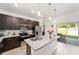 Modern kitchen featuring a granite island with dark cabinets and stainless steel appliances at 10871 Sw 62Nd Avenue Rd, Ocala, FL 34476