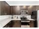 Modern kitchen features granite countertops, stainless steel appliances, and dark cabinets at 10871 Sw 62Nd Avenue Rd, Ocala, FL 34476