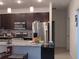 Modern kitchen with dark cabinets, granite countertops, and stainless steel appliances at 10871 Sw 62Nd Avenue Rd, Ocala, FL 34476