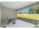 Covered patio with seating area overlooking a spacious, well-maintained backyard at 10871 Sw 62Nd Avenue Rd, Ocala, FL 34476