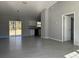 Open living area with gray walls, tile floors, and kitchen access at 14 Locust Pass Run, Ocala, FL 34472