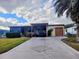 Single story home with carport and palm trees, and landscaped lawn at 1628 Bay Meadows Ln, The Villages, FL 32159