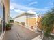 Side backyard featuring a concrete patio area, lush plants, and a white fence at 17163 Se 76Th Boxbury Ct, The Villages, FL 32162