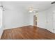 Empty bedroom with hardwood floors, white walls, ceiling fan, and a view into the bathroom at 17163 Se 76Th Boxbury Ct, The Villages, FL 32162