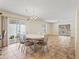 Cozy dining area with a chandelier, open to the kitchen and living spaces with neutral tones at 17163 Se 76Th Boxbury Ct, The Villages, FL 32162