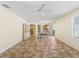 Open-concept dining room with tan tile flooring, a dining table, a ceiling fan, and access to the kitchen at 17163 Se 76Th Boxbury Ct, The Villages, FL 32162