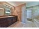 Bathroom with dark wood vanity, granite countertop, and bathtub at 20 Fisher Trail Pass, Ocklawaha, FL 32179