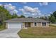 Newly constructed single-story home with a two-car garage and a neatly landscaped yard at 20 Fisher Trail Pass, Ocklawaha, FL 32179