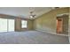 Large main bedroom with carpeting, ceiling fan, and sliding glass doors to the backyard at 20 Fisher Trail Pass, Ocklawaha, FL 32179