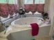 Luxurious soaking tub set in a tile-surround bathroom with elegant window treatments at 22777 Sw Surf Blvd, Dunnellon, FL 34431
