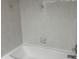 Bathroom with white tiles and a tub with silver hardware at 22777 Sw Surf Blvd, Dunnellon, FL 34431