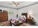Cozy bedroom with a queen bed, dresser and window at 22777 Sw Surf Blvd, Dunnellon, FL 34431