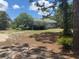 Rear exterior view of home with a small deck and backyard, surrounded by mature trees at 22777 Sw Surf Blvd, Dunnellon, FL 34431