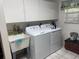 Laundry room with white appliances, cabinets, and a sink at 22777 Sw Surf Blvd, Dunnellon, FL 34431